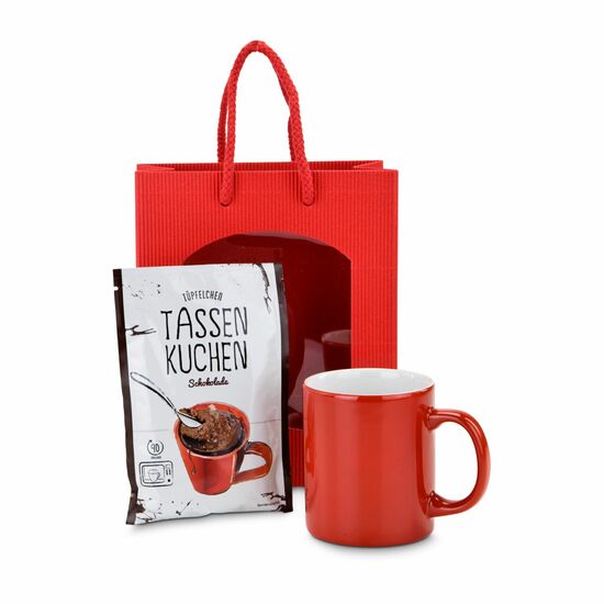 Schnell und lecker: ein Kuchen für zwischendurch - eine rote Geschenktüte, eine rote Tasse und eine Backmischung für einen Tassenkuchen.