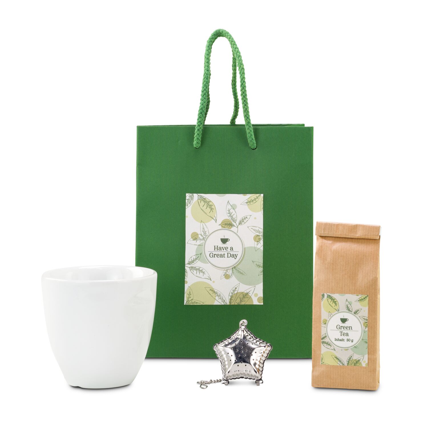 Ein Päckchen grüner Tee, ein silbernes Tee-Ei und ein Porzellan-Thermobecher befinden sich in dieser grünen Tüte mit Aufkleber.